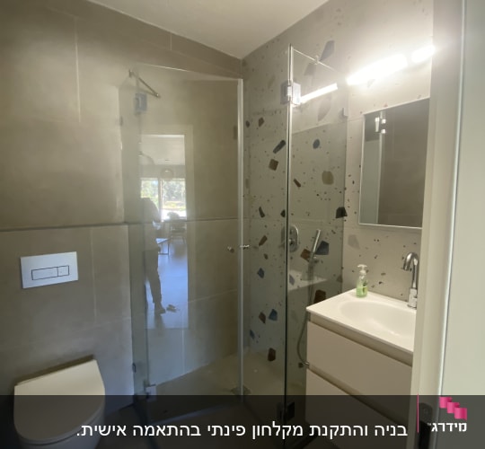 מקלחון זכוכית עם דלת פתוחה ומקלחת יד